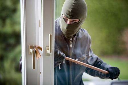 Einbrecher an einem Fenster