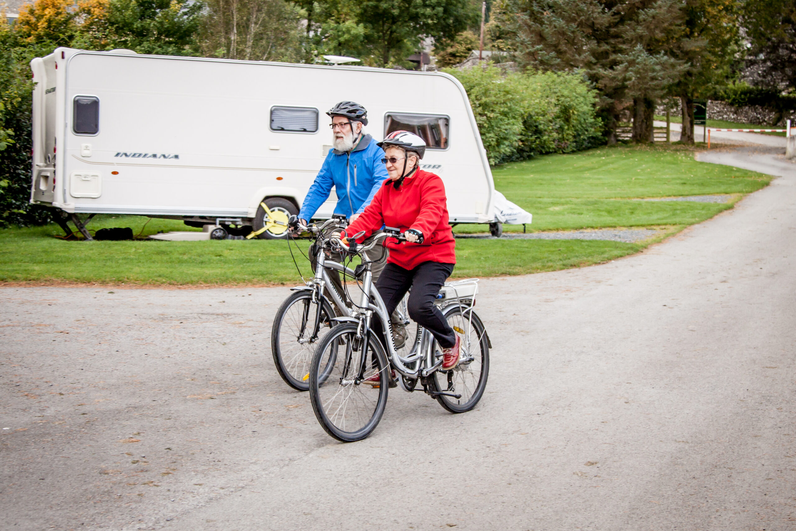 Cyclists on Electric bikes passing a caravan