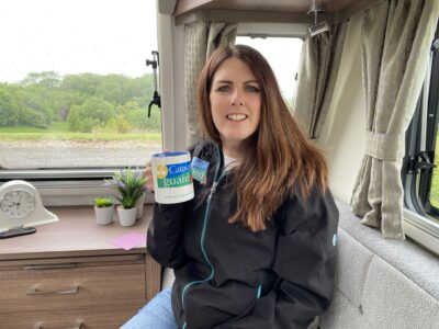 Liz with cup of tea in a caravan